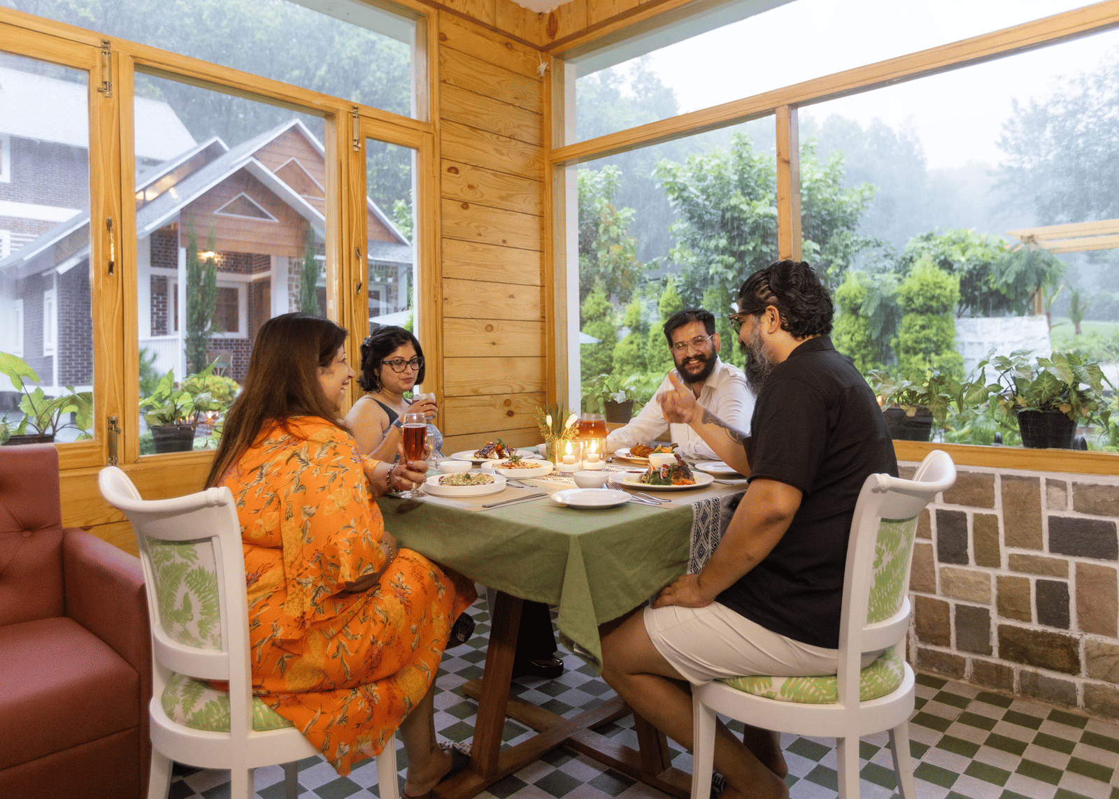Guests enjoying a relaxed conversation over tea in a bright cafe - Megha Resort & Villas, Dehradun