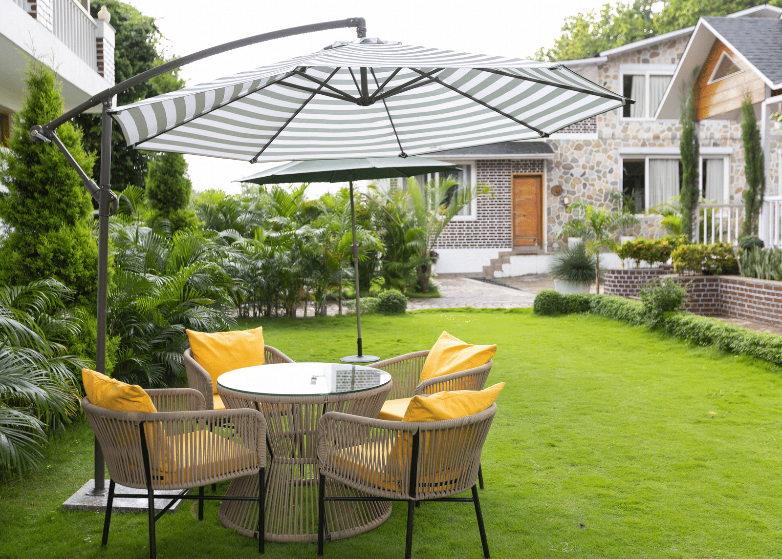 An outdoor seating area with yellow chairs under a stylish gazebo - Megha Resort & Villas, Dehradun