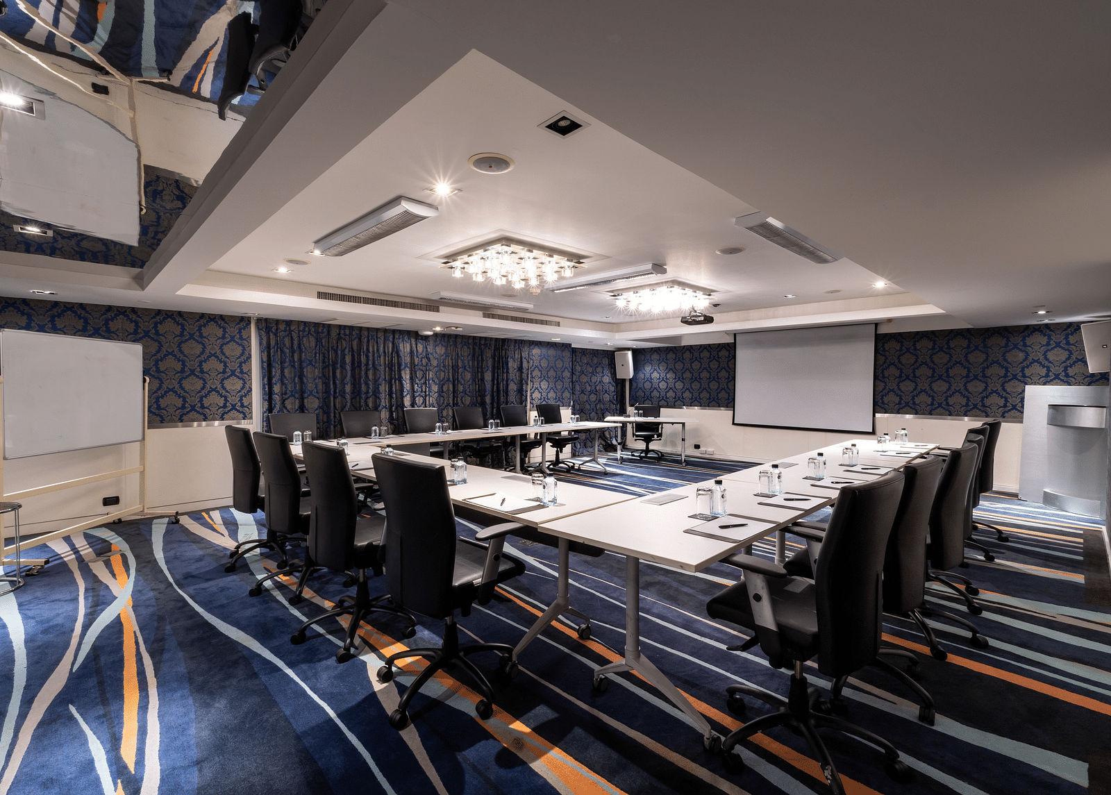 An overview of a meeting room with projector, table and seats in view - Night Hotel Bangkok.