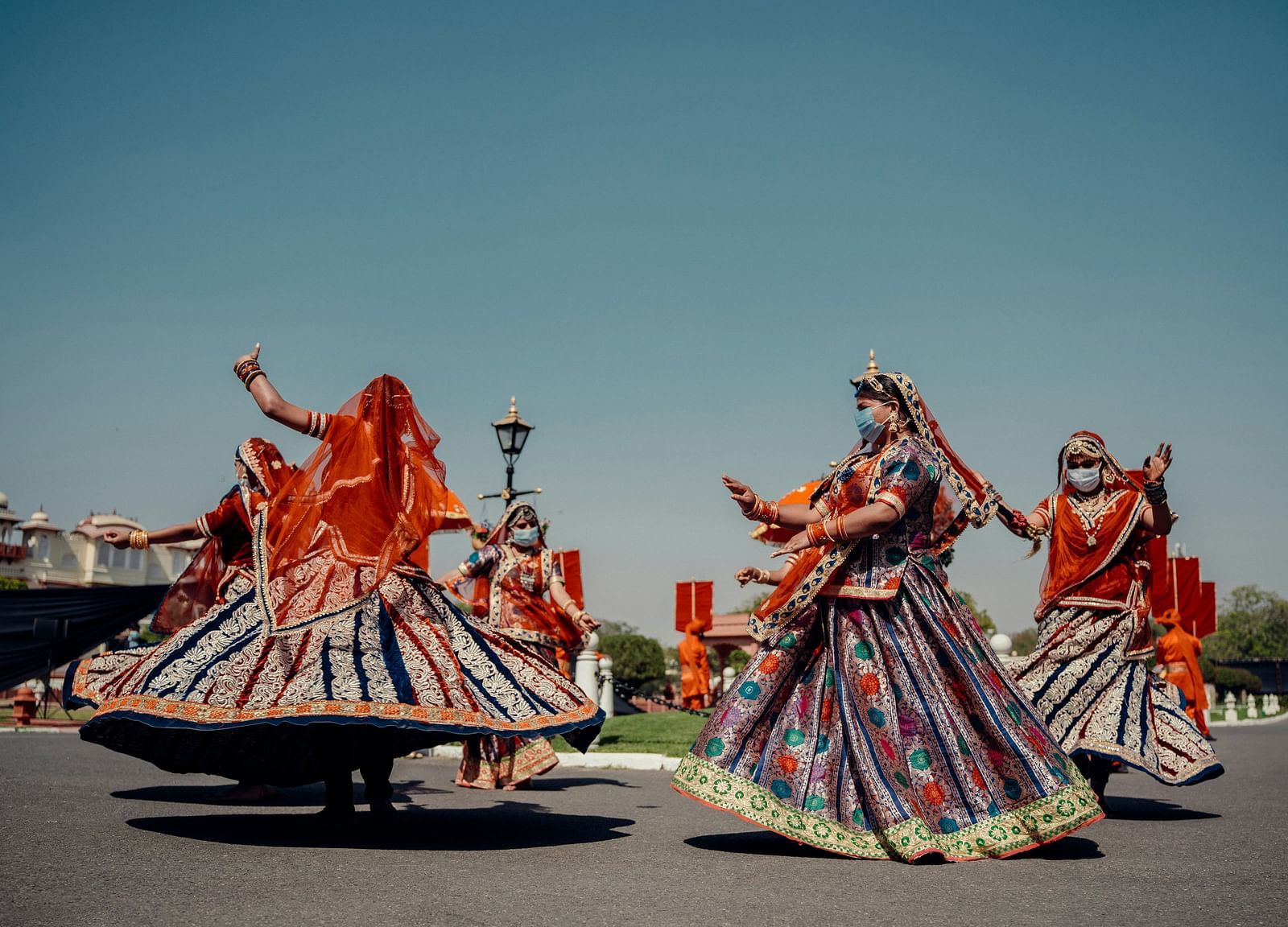 Three women in traditional Rajasthani attire performing a dance.