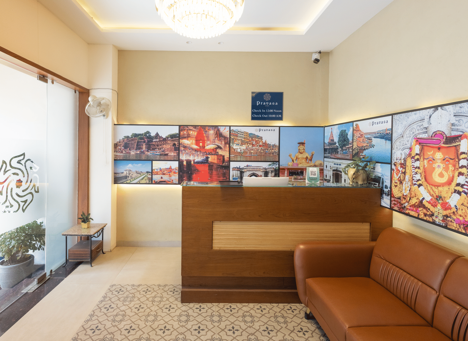 Interior view of the reception desk and seating area with decorative wall art at Pravasa Stay Luv Kush, Indore.