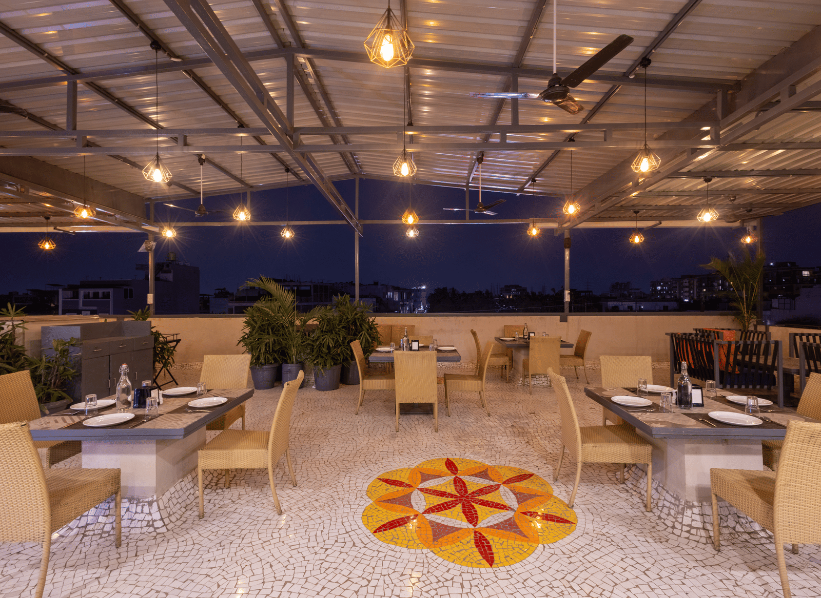 Exterior view of the rooftop terrace with tables and chairs at Pravasa Stay Luv Kush, Indore.