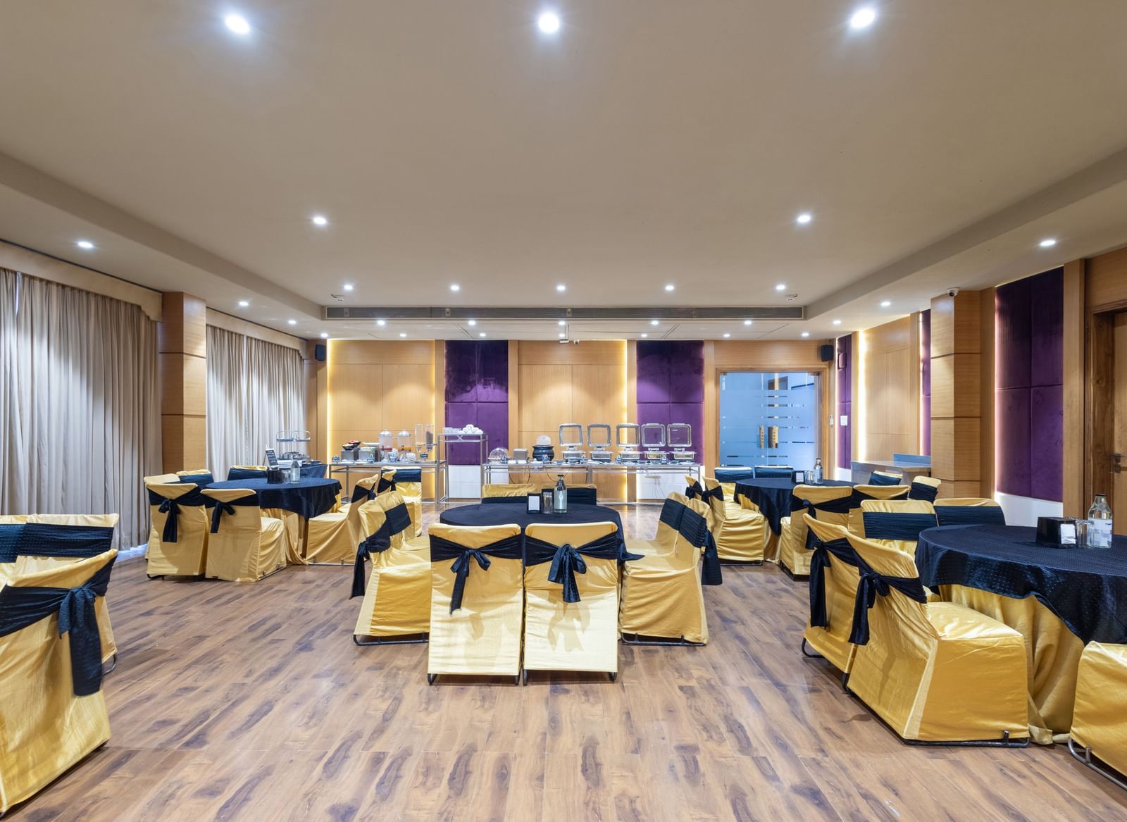 Banquet hall, Iris, with tables in cluster seating arrangment, wooden flooring, seen at Pravasa Stay Vijay Nagar, Indore.