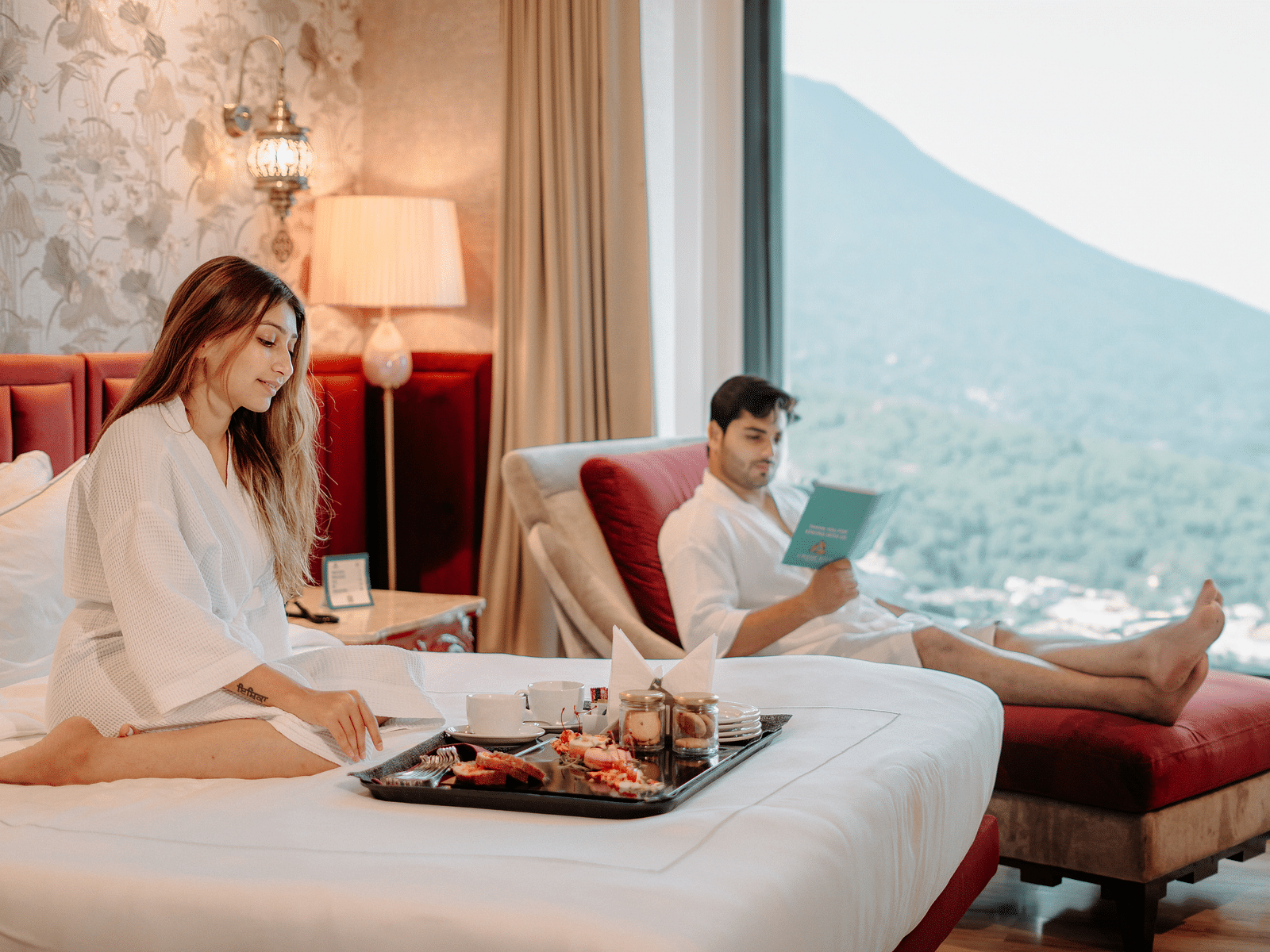 A couple enjoying in-room dining while relaxing on the furniture at Crescent Spa & Resort, Indore