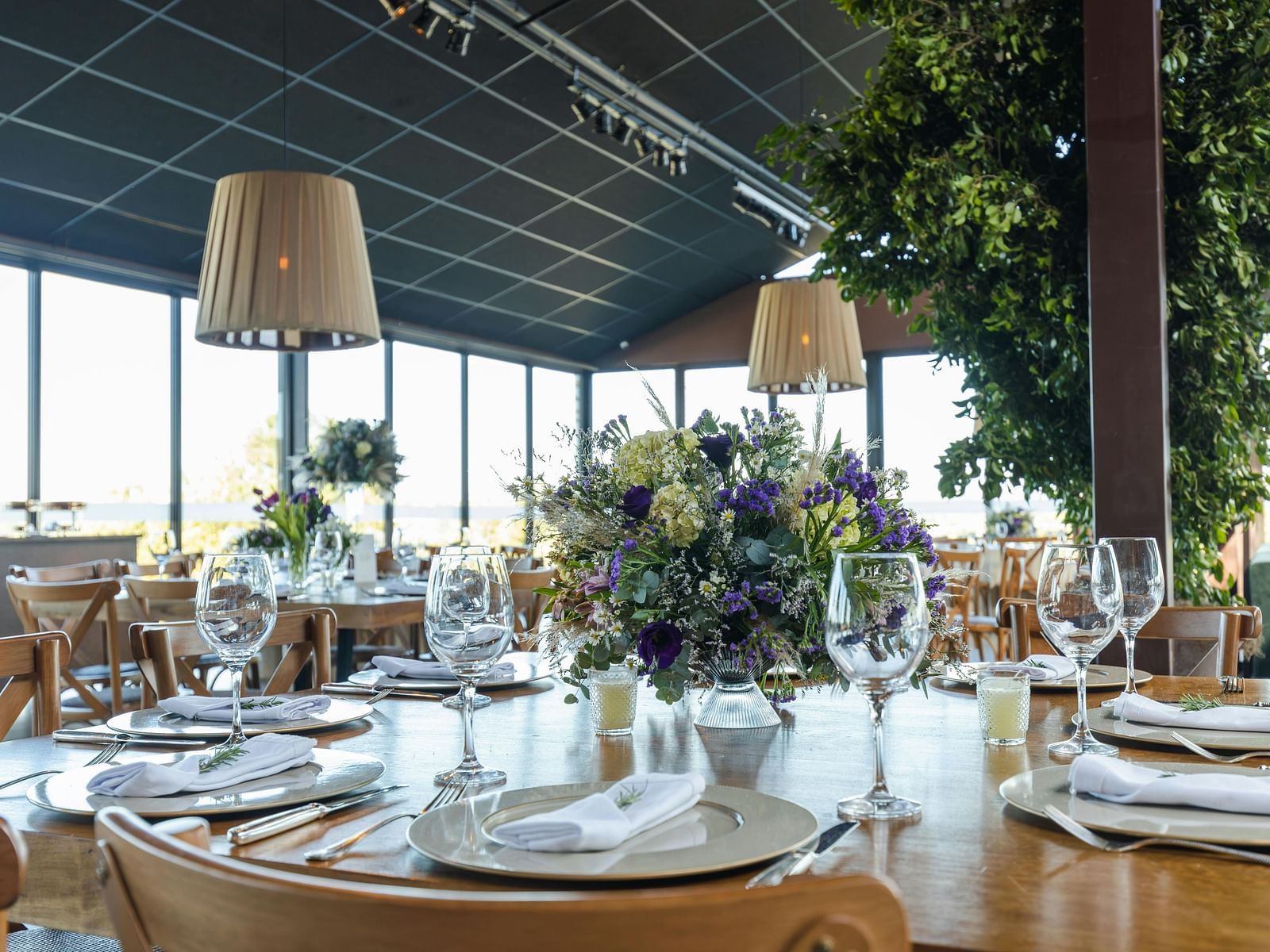 A banquet hall decorated for a celebration, with tables dressed in cloths and culinary delights ready for serving