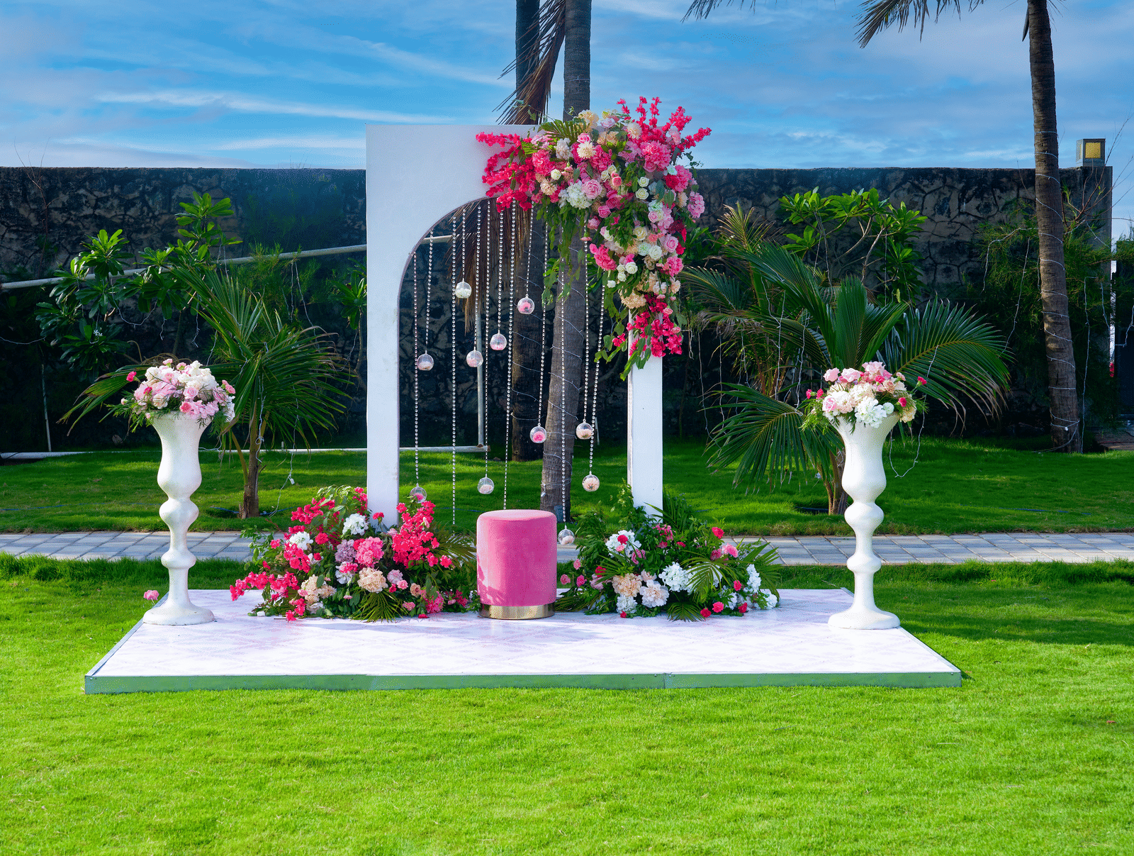 White arch backdrop adorned with fresh flowers on a manicured lawn - Grande Bay Resort & Spa, Mamallapuram