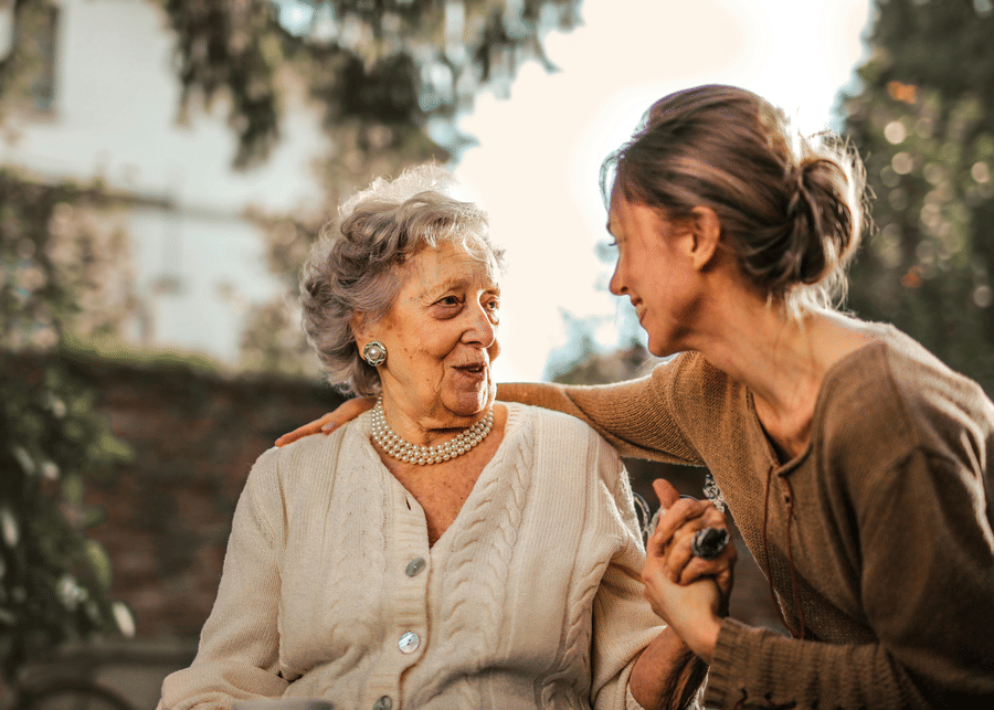 A photo showing a young girl affectionately spending time with a senior citizen at the golden hour.