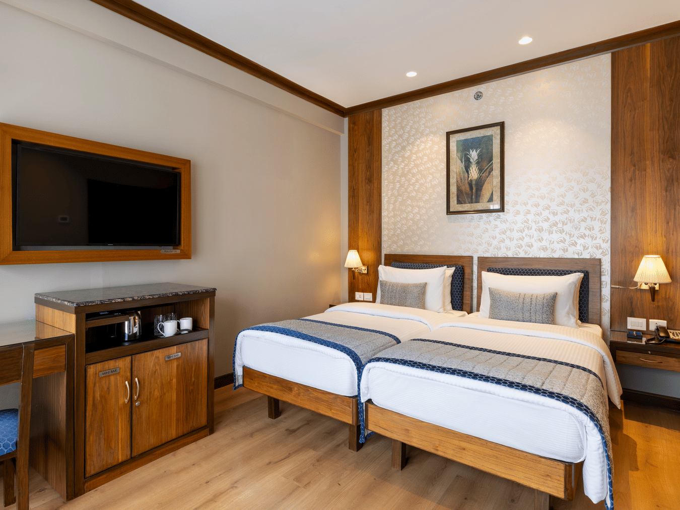 Executive Room with twin beds and a wall mounted television at Kenilworth Hotel, Kolkata.