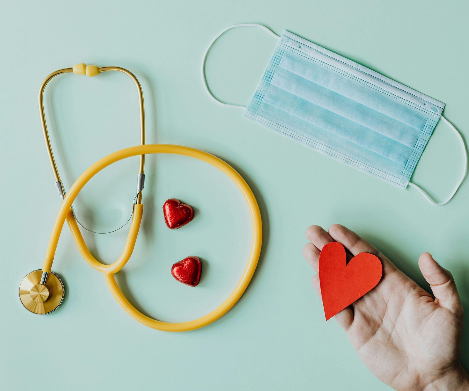 An image of stethoscope, some tablets, and a mask