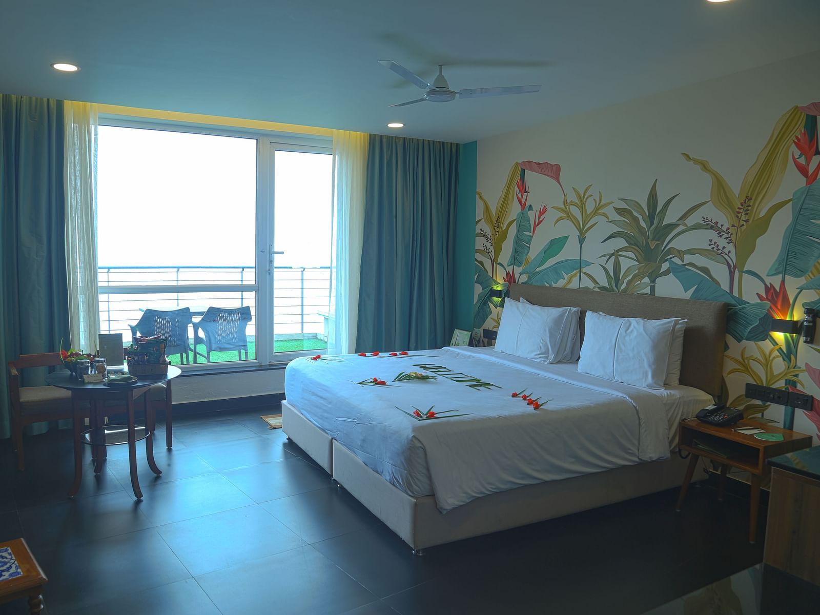 Image of valley view room with king size bed, flat screen TV, an expansive glass door leading to the balcony - An image of a a valley view room with king size bed, bed side table, flat screen TV, wardrobe, air-conditioner, and decorative items - Great Trai