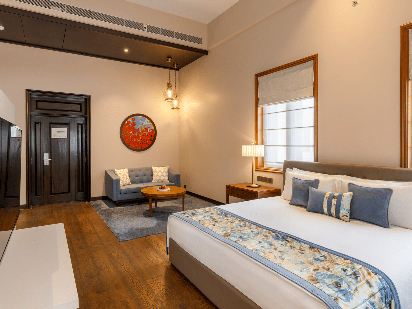 Premier Club Suite with a bed, seating area and wall mounted television at Kenilworth Hotel, Kolkata.