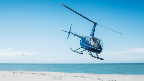 helicopter taking off from a helipad near the sea