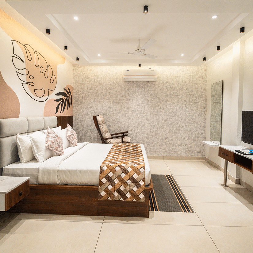 An image of a hotel bedroom with a large bed placed in front of a wall-mounted television - MGM Whispering Meadows