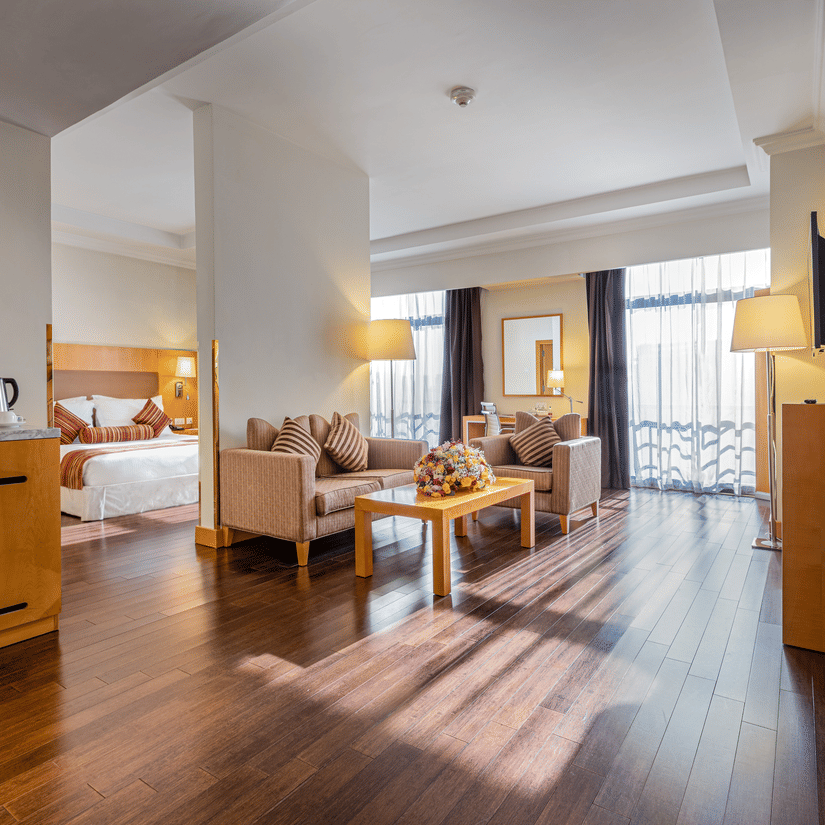 A bedroom having a king size bed with the living room in the foreground having sofas and a coffee table at the Executive Suite in Ramada by Wyndham Addis, a 4-star hotel in Addis Ababa