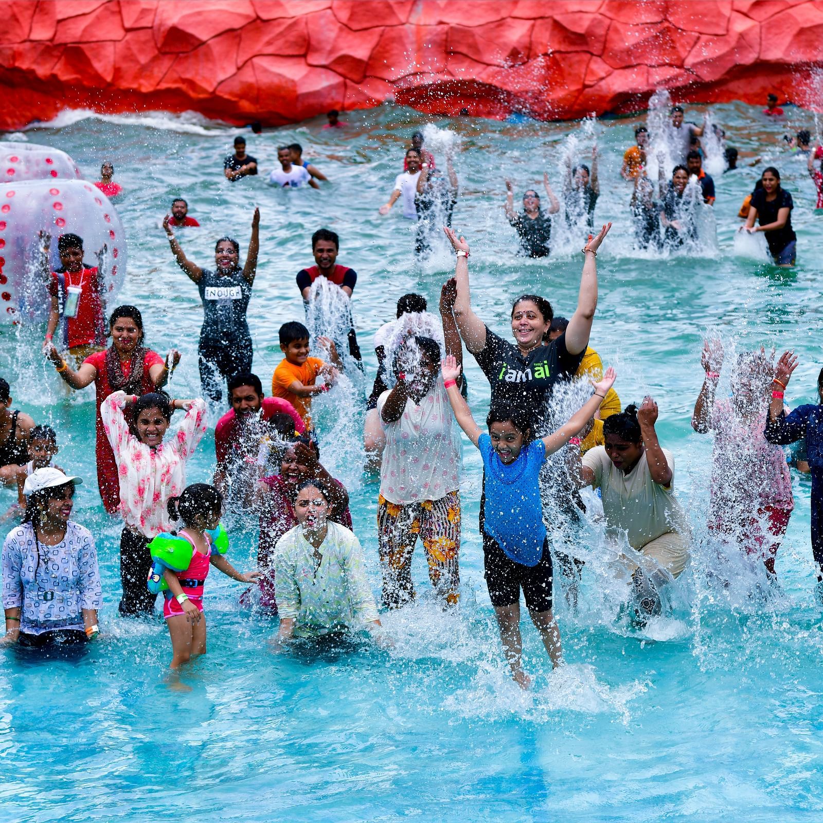 An overview of a wave pool inside Diamond Parks, Pune, with a group of people posing for a picture.