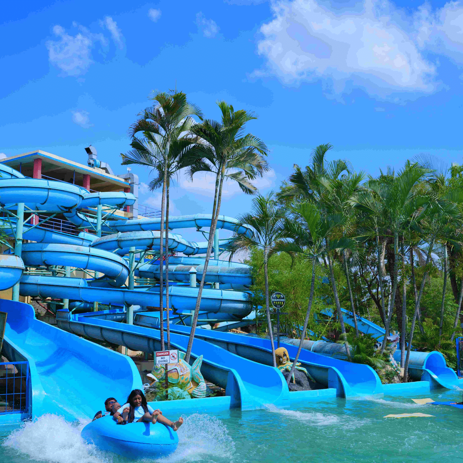 An overview of a spiral water slide with many people sliding down inside the waterpark at Diamond Parks, Pune - The Best Place for Photoshoot in Pune.