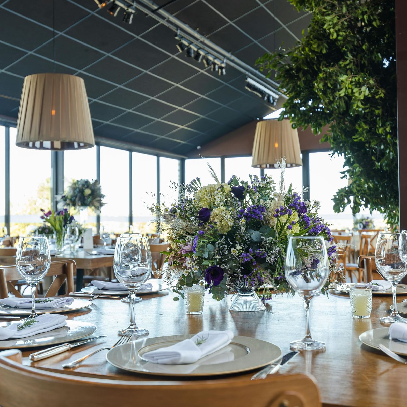A banquet hall decorated for a celebration, with tables dressed in cloths and culinary delights ready for serving