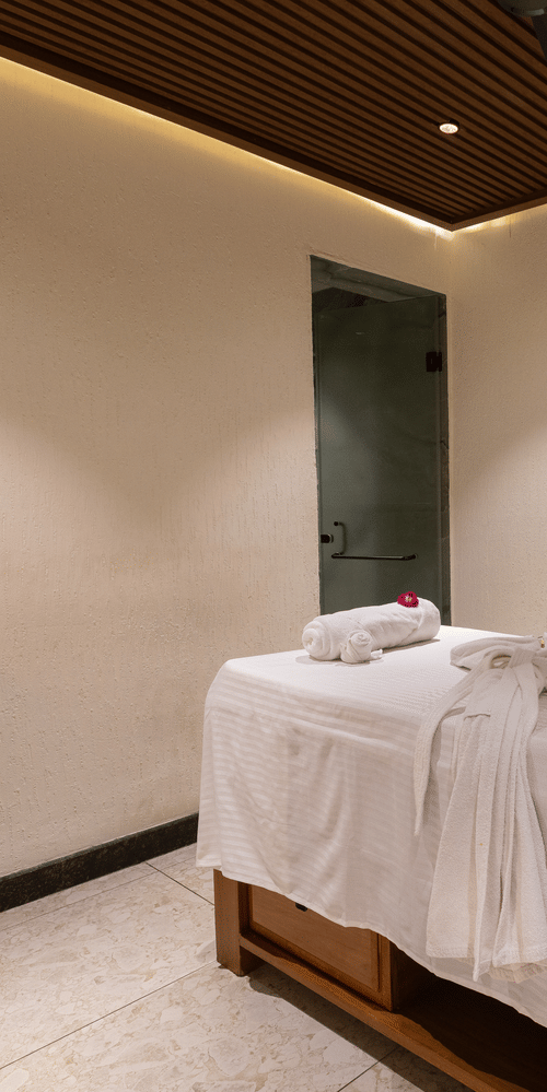 A single, dimly lit spa treatment room with one massage table at The Golden Tusk, Jim Corbett