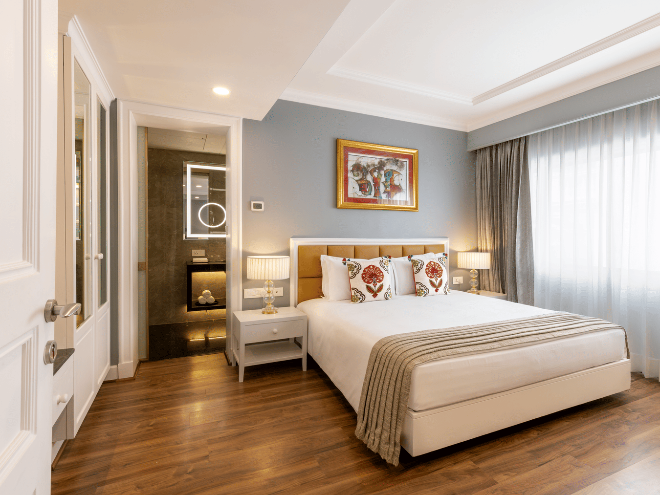 Junior Suite with a bed and framed artwork near the room entrance at Kenilworth Hotel, Kolkata.