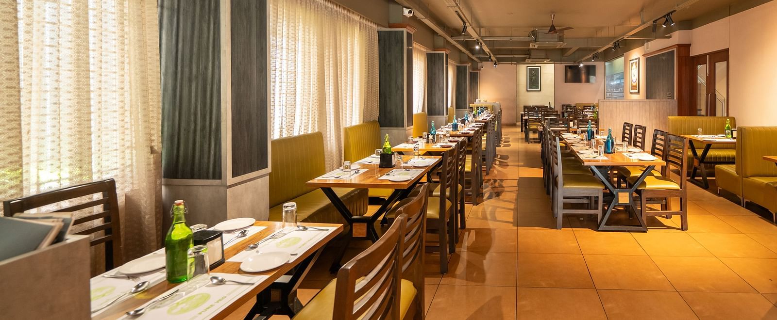Image of a dining area with a photo frame mounted on the wall on the side at Hari Govindas, Siddappa Square.