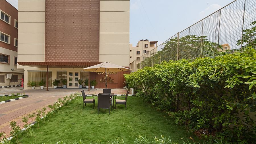 An image of our lawn in front of our hotel building with sun loungers, chairs, a teapoy - Grand Continent, Brookefield