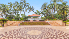 Geometric patterned courtyard with palm trees and a central pavilion at the far end.