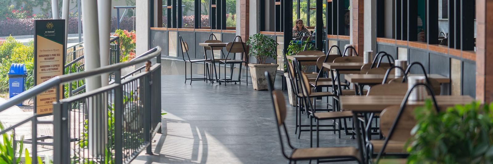 Outdoor dining area at Hari Govinda's, where tables and chairs are set beside the wall