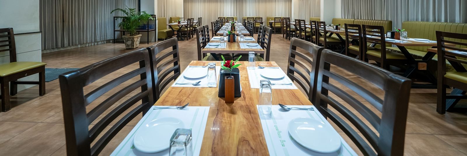 Dining area with close up view of the neatly set table and chairs kept on both sides of the table