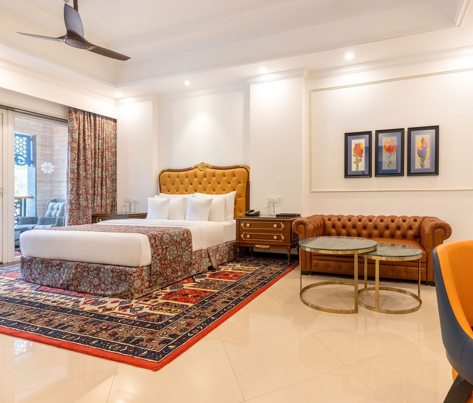 Double bedroom with a seating space, a workstation, ceiling fan, and large Glass windows at MAYFAIR Palm Beach Resort, Gopalpur-On-Sea