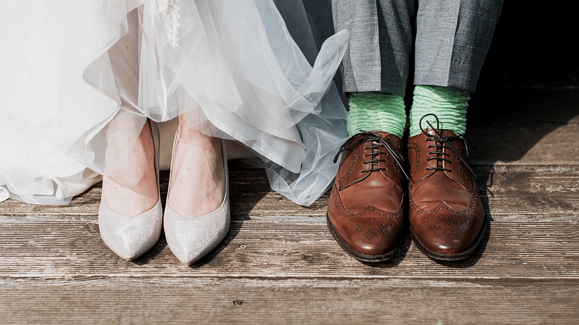 a close up shot of a a couple showing their feet in their wedding attire