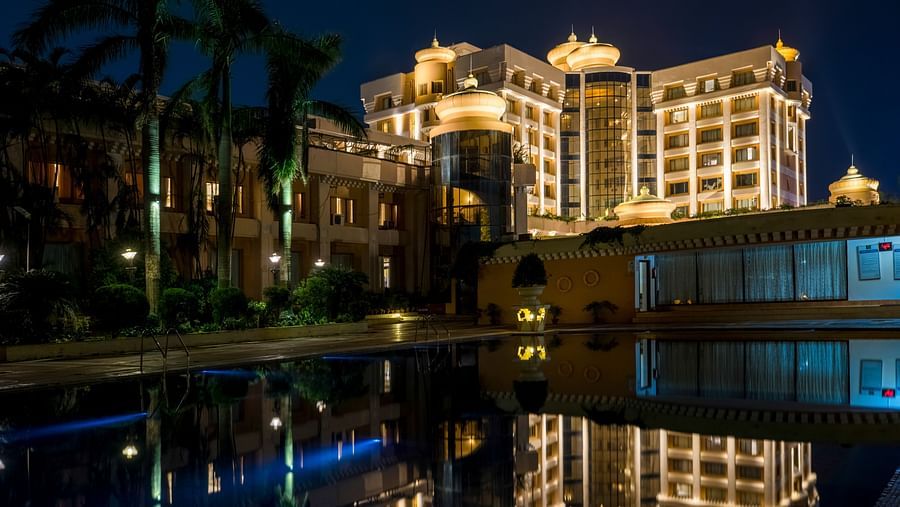 Facade view of Swosti Premium, Bhubaneswar at night, with its reflection in the water surface.