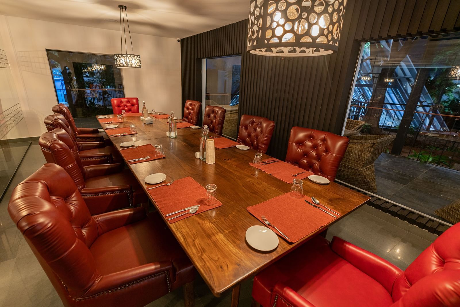 image of a long wooden dining table inside the mekong restaurant lined with brown leather chairs - Darza Resorts