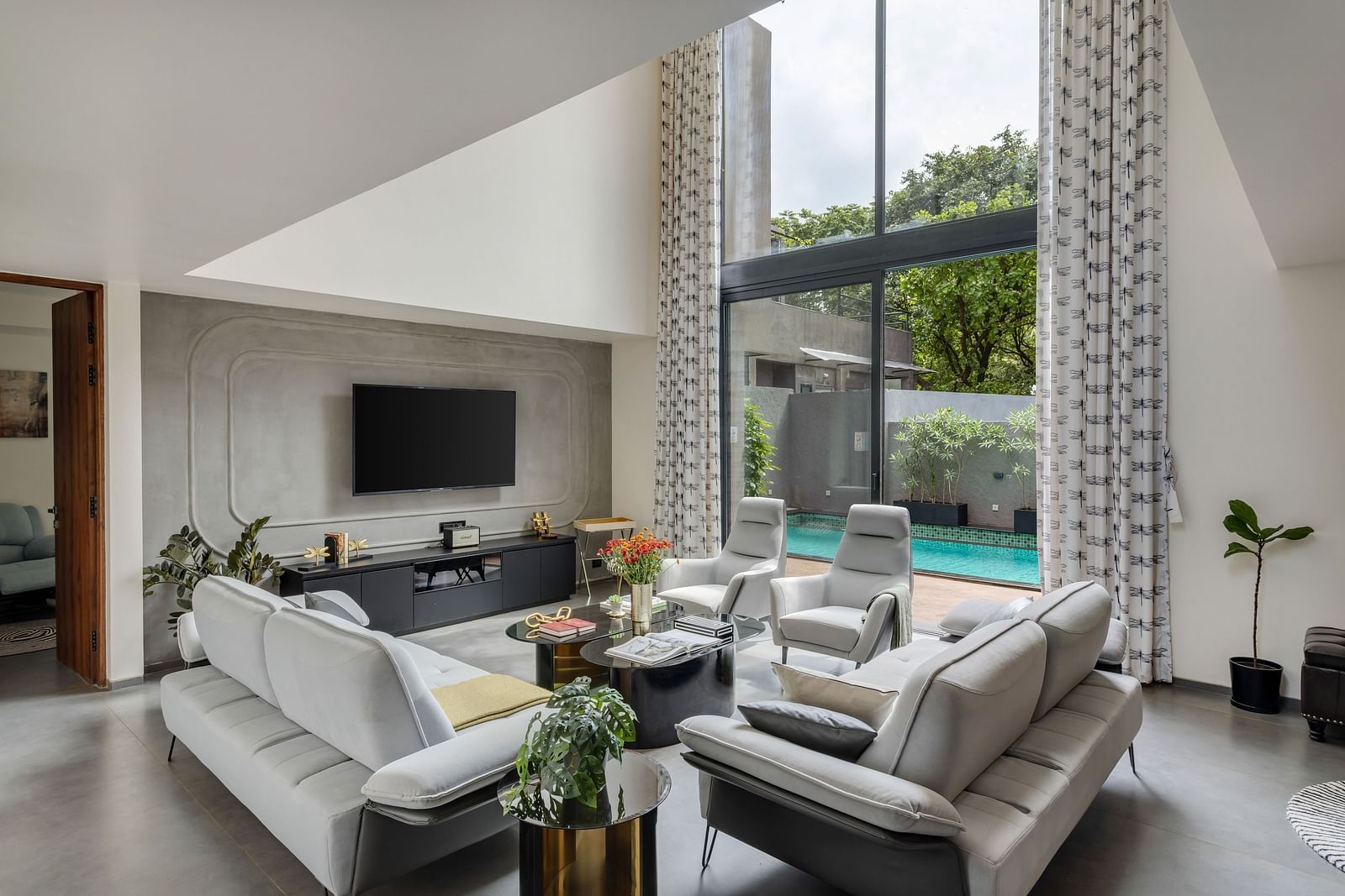Corner view of the living room at Lindsay Manor, featuring a sofa, TV, chairs, and a tea table.