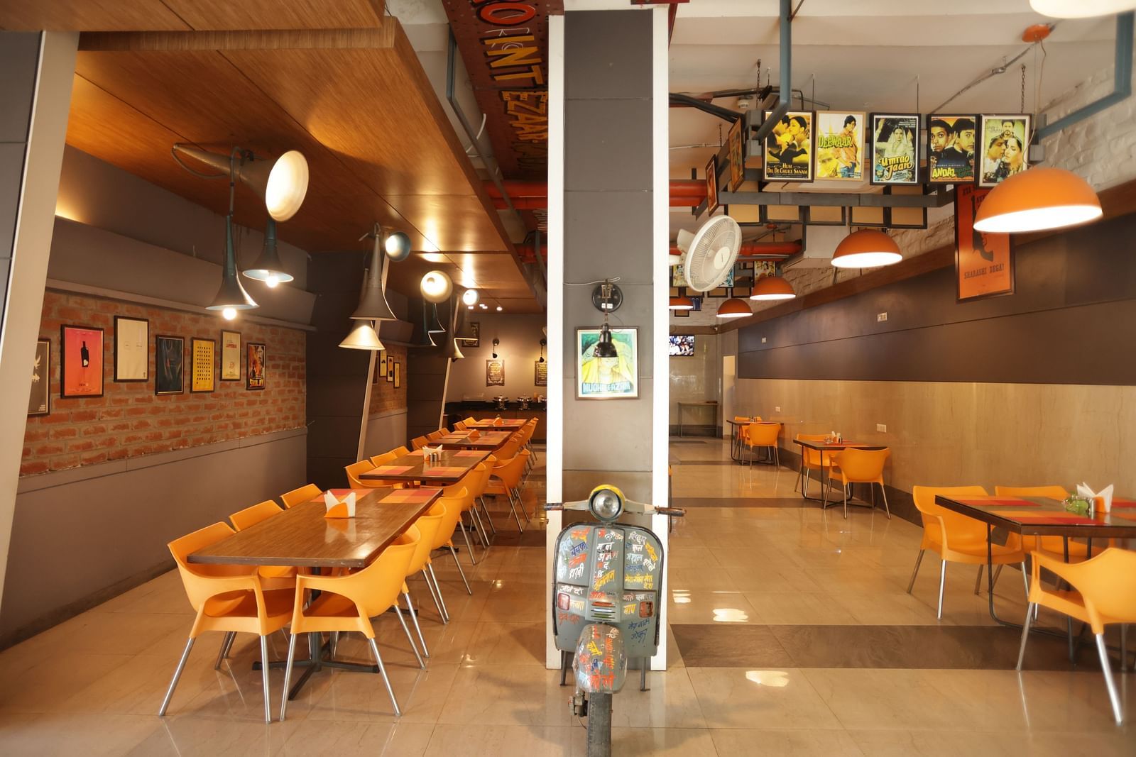 front view image of the dining area with a decorative vintage two wheeler kept in the entrance - Max Hotel, Jabalpur