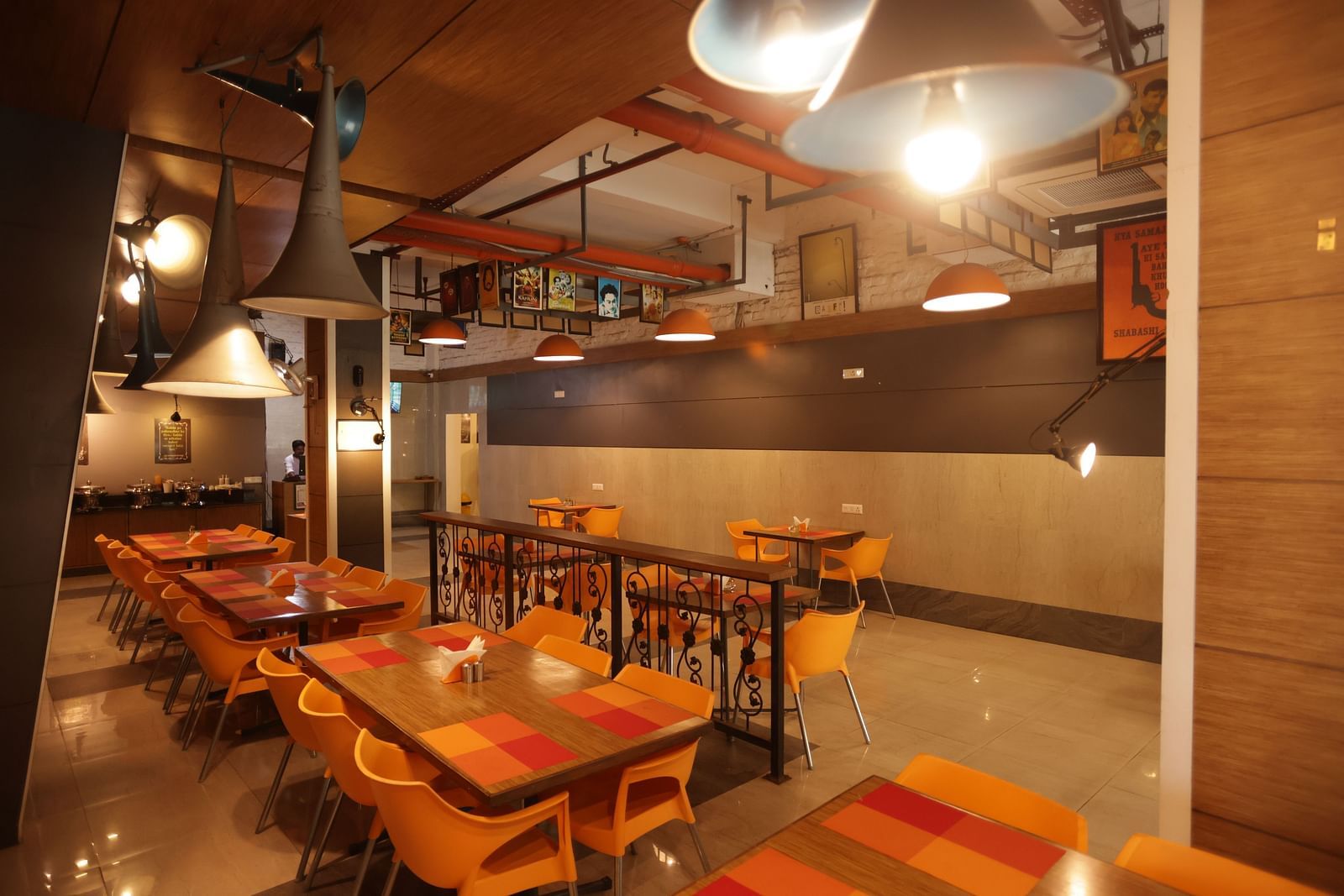The interior of the Mumbai Masala restaurant at Max Hotel Prayagraj, featuring tables and chairs set for dining.