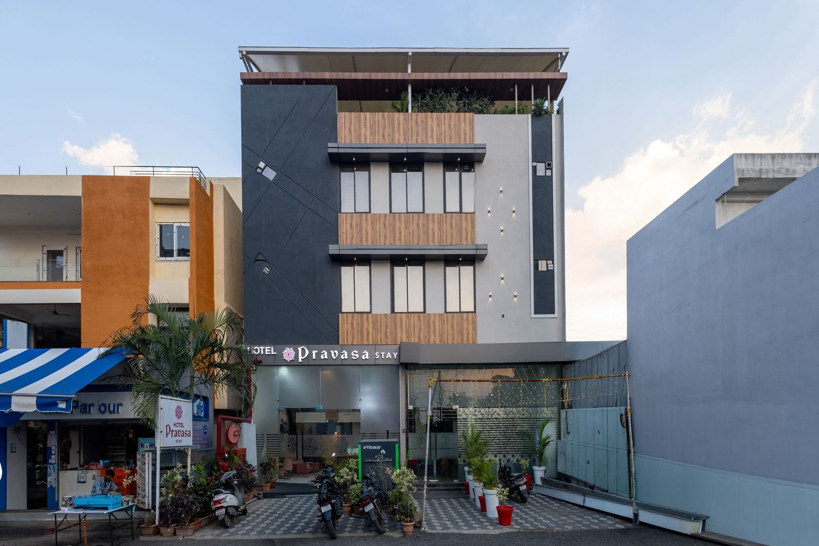 The facade of a modern multi-storey Pravasa Stay Dewas Naka, Indore under the blue sky.