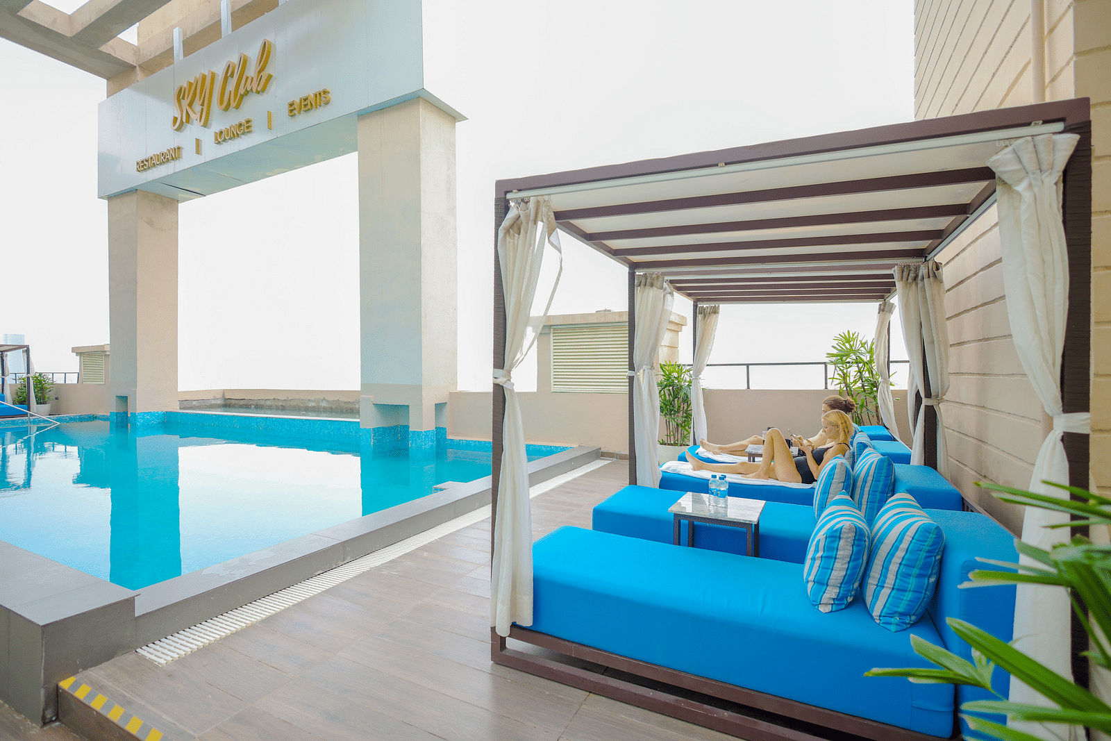 an image of a crystal clear swimming pool with sun decks at Rhythm Gurugram.