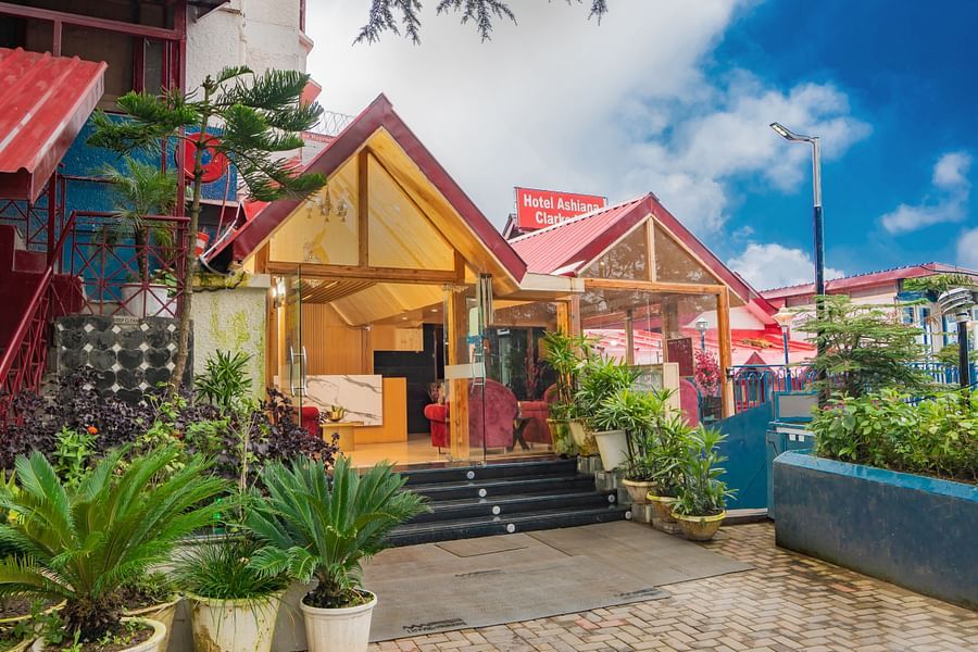 An image featuring tents with plants kept next to their entrances under blue sky