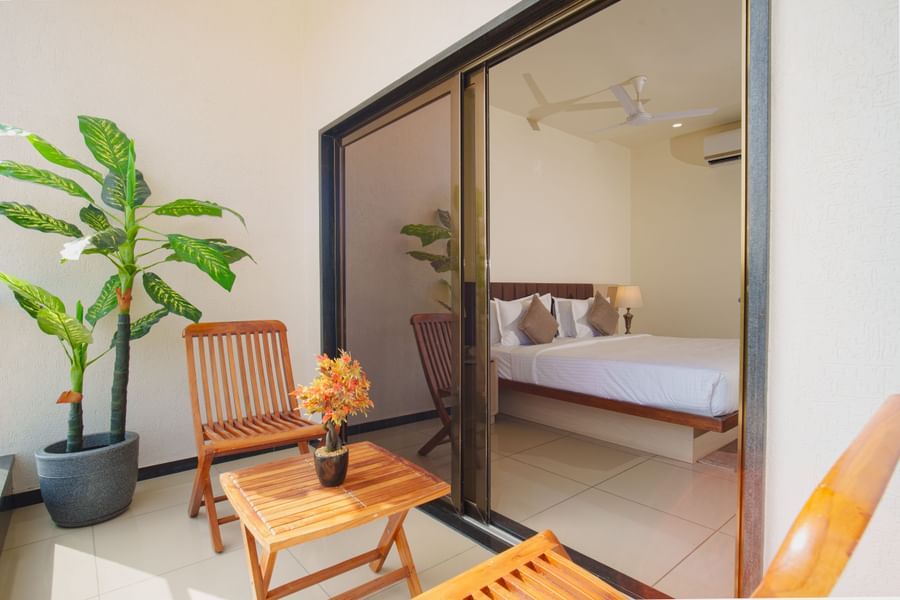 Hotel room view showing a small seating area on an outdoor balcony or patio next to a glass door at Arawali Ananta Elite, Jaipur.