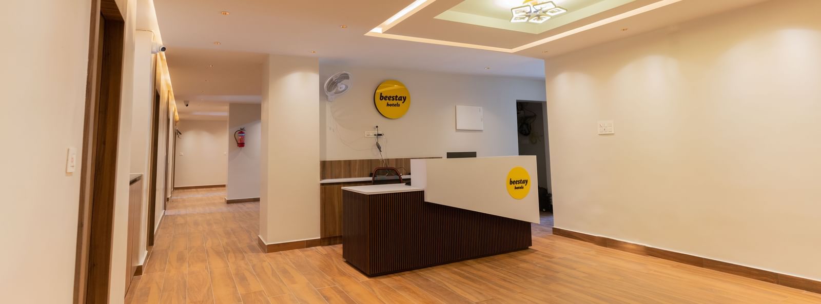 Spacious front desk area with wooden flooring and bright interiors at Beestay Hotels, Rajahmundry.