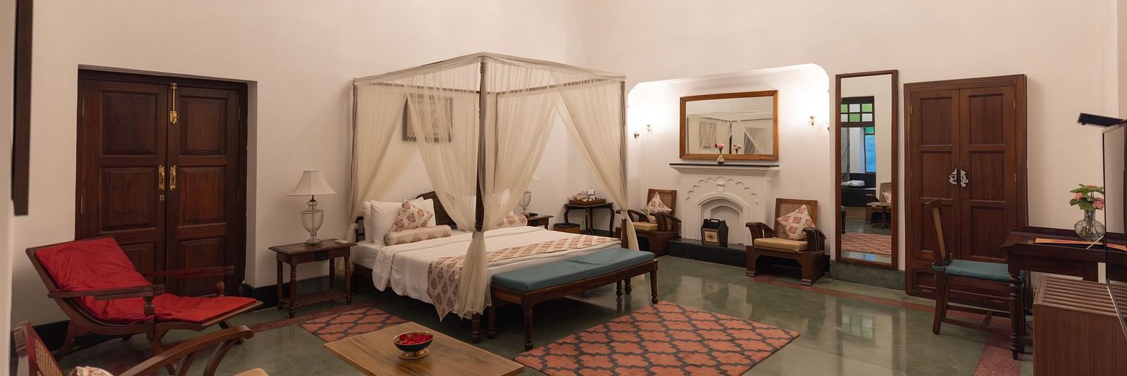 Imperial Suite at Saraca Hotel, Lucknow with a double bed placed in the centre of the room with small carpets placed around it