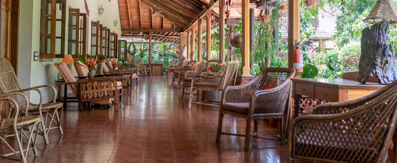 Covered walkway or verandah with wooden pillars and comfortable seating - BluSalzz Collection - Tranquil Resort, Wayanad