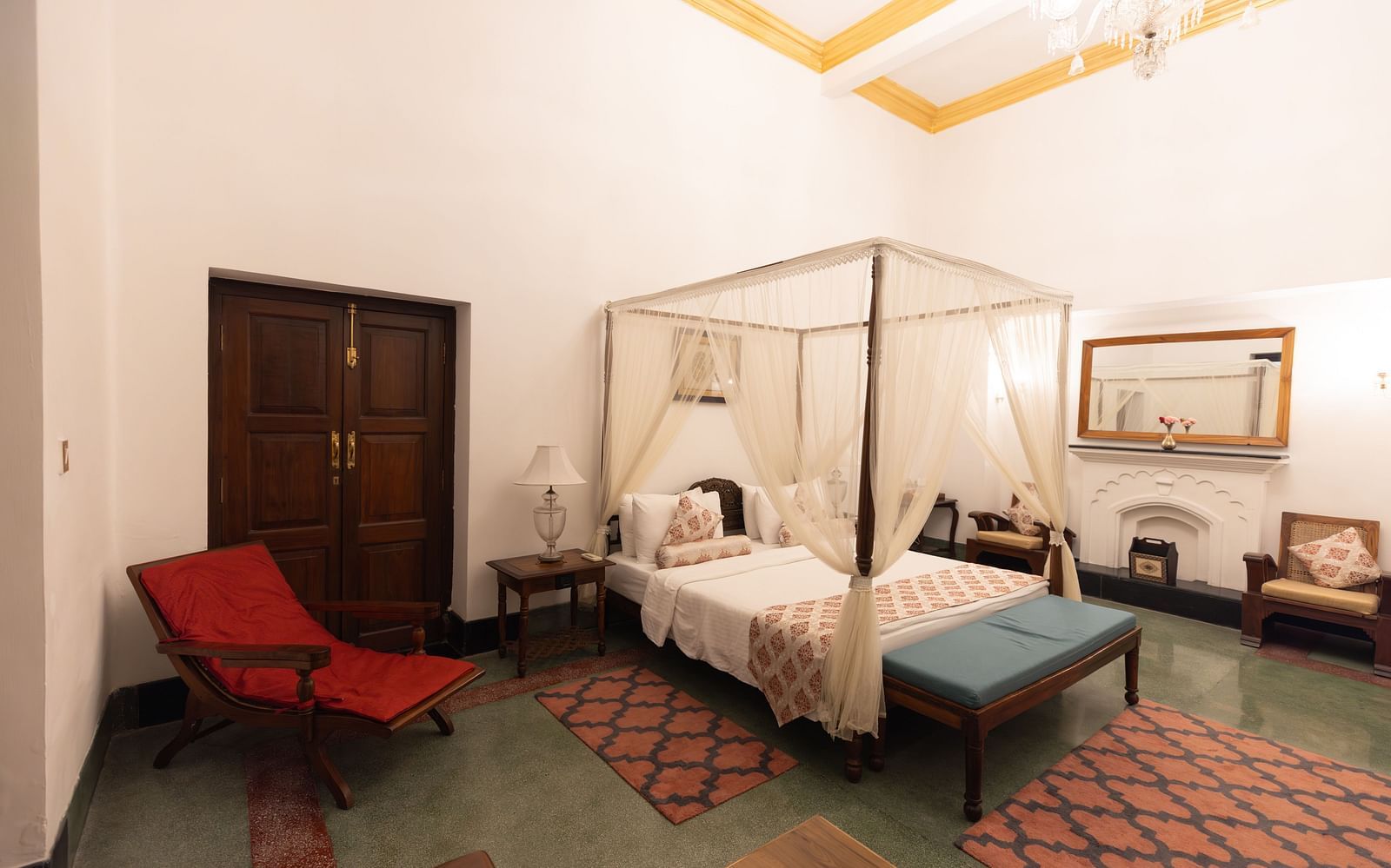 Imperial Suite at Saraca Hotel, Lucknow with a double bed placed in the centre of the room with a lounging chair placed besides it