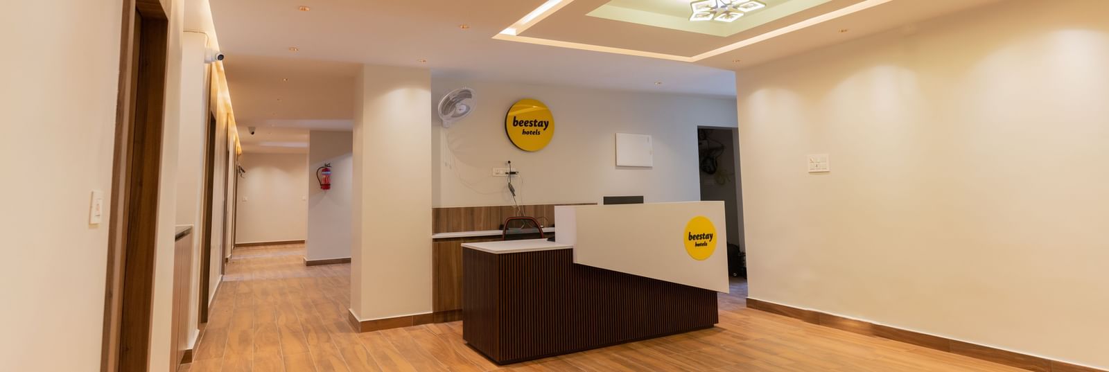 Spacious front desk area with wooden flooring and bright interiors at Beestay Hotels, Rajahmundry.