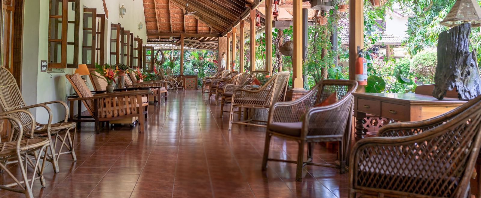Covered walkway or verandah with wooden pillars and comfortable seating - BluSalzz Collection - Tranquil Resort, Wayanad