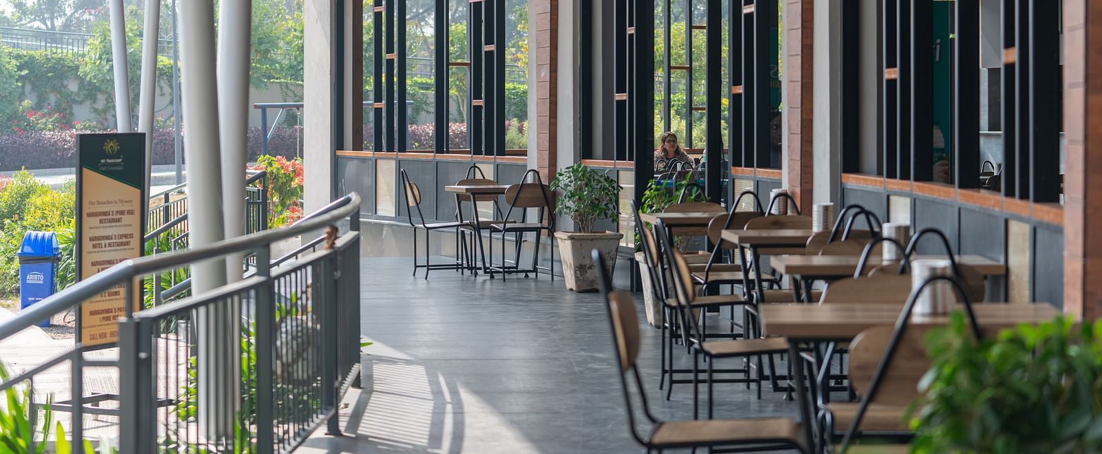 Outdoor dining area at Hari Govinda's, where tables and chairs are set beside the wall