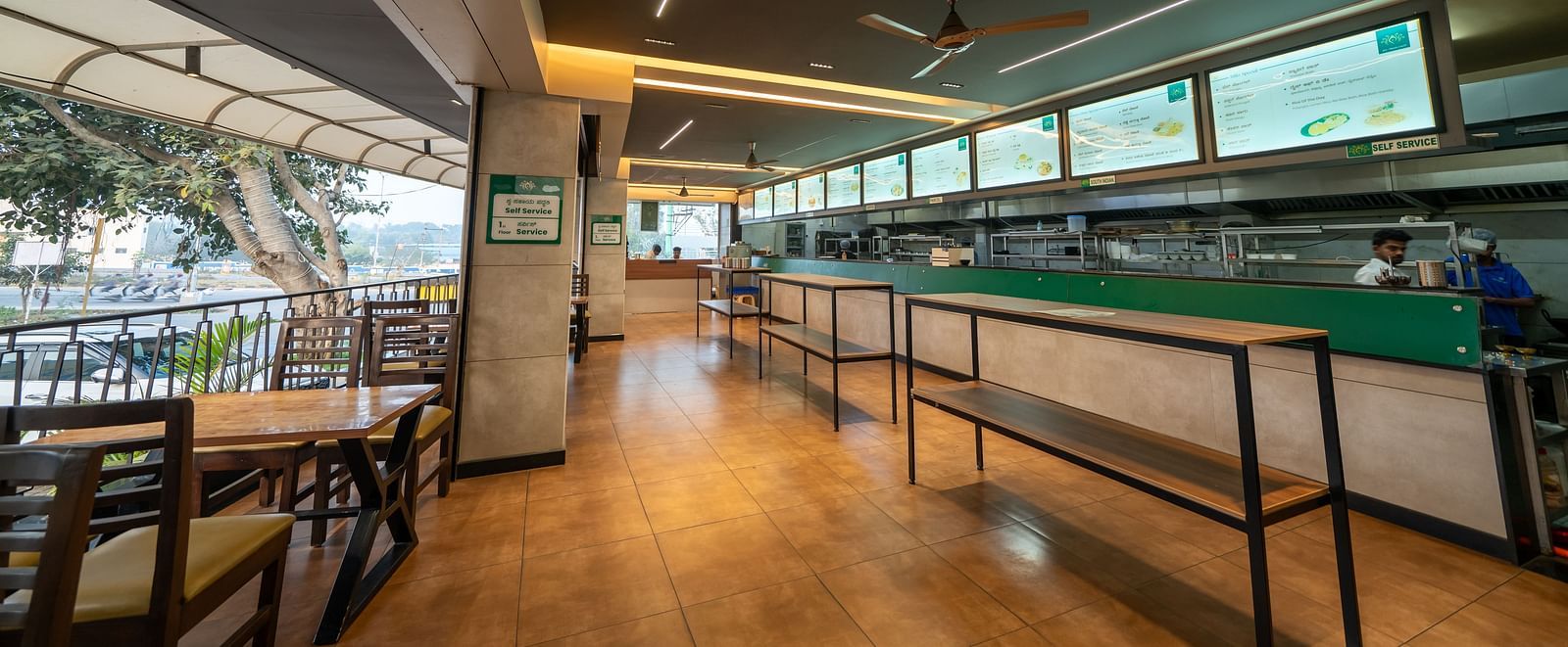 Dining area at Hari Govinda's with seating at a table and chairs on one side, while the other side features tables alone near the counter