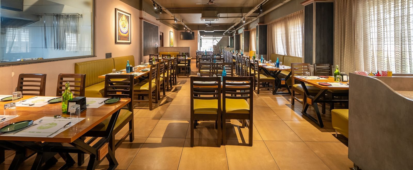 Image of a dining area with wooden tables and chairs at Hari Govindas, Siddappa Square.