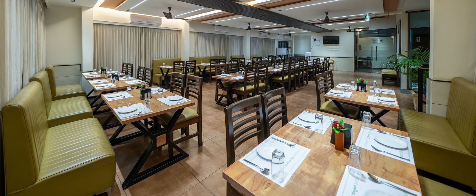 Dining area with close-up view of the neatly set table and chairs kept on both sides of the table at Hari Govinda's