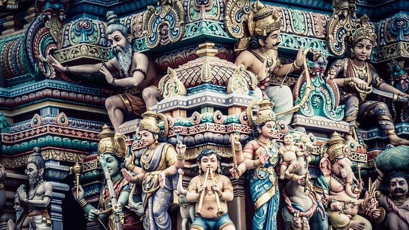 A facade image of a temple with faces of the gods